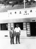 Village representative Mr. TANG SHANG (鄧生)  with Mr. W.R. (Dick) NORMAN, District Assistant, District Office, Tsuen Wan, who "wrote" the characters for the new school.  His name in Chinese is 羅文. (Image)