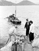 Villagers collecting water from a visiting sampan, 1963