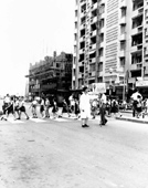 A traffic warden holding up traffic for the children at North Point, 1962