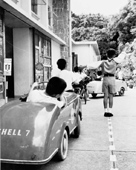 Children learning the rules of the road on a traffic layout set up at a school, 1962